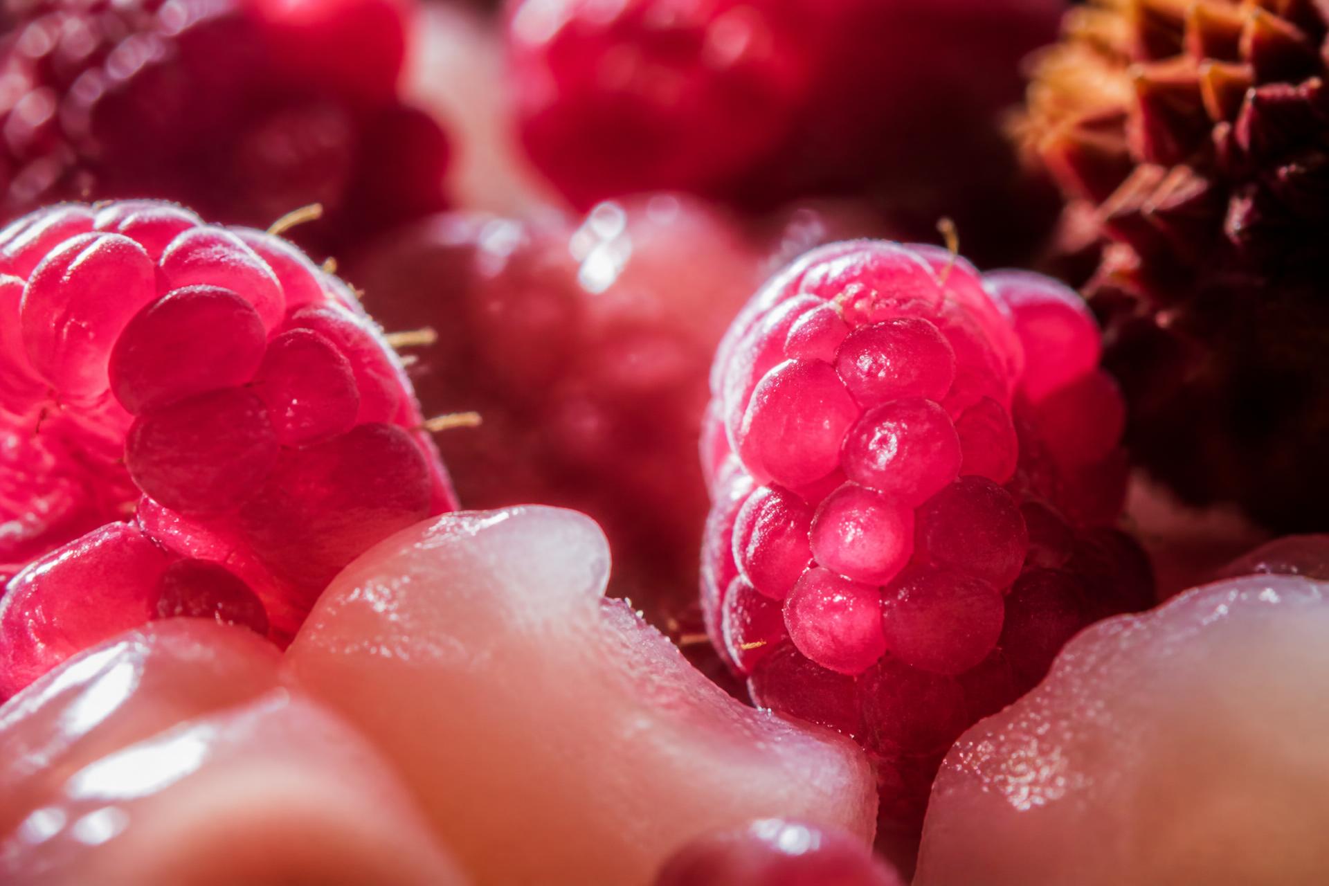 Macro photograph of fresh raspberries and peeled litchi