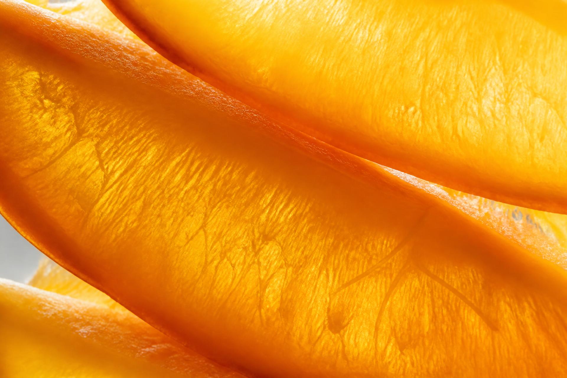 Macro photograph of glistening ripe mango slices